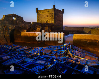 ESSAOUIRA, MAROKKO - ca. Mai 2018: Sonnenuntergang über dem Hafen von Essaouria und die berühmten Castelo Real von Mogador. Stockfoto