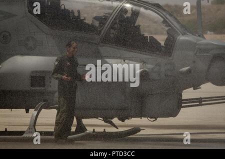 Us Marine Corps Maj. Jasmin Moghbeli, ein Pilotprojekt zu Marine Test und Bewertung Squadron (VMX) 1, steht Ihr AH-1 Cobra' als Marines Marine Corps Air Station Yuma, Ariz., Flugzeuge Rettung und Brandbekämpfung (ARFF) Spray und Arch von Wasser als Teil eines traditionellen 'Wet' Juli 7, 2017 zugewiesen. Maj. Moghbeli Berichten dem Johnson Space Center in Houston, Texas, später in diesem Jahr der NASA-Astronaut Kandidat Klasse von 2017 zu besuchen. Stockfoto