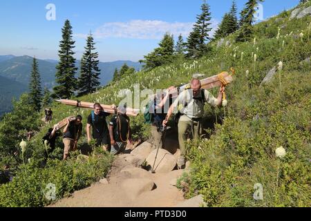 Soldaten aus dem 4., 1. Special Forces Group (Airborne) geführt von einer U.S. Forest Service Ranger führen Schnittholz bis Granit Berg, Wa. Die sturmblendenverschlüsse auf dem Feuer Aussichtsturm am 7. Juli 2017 wiederherzustellen. Stockfoto