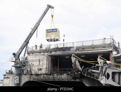 KEY WEST, Florida (10 Juli 2017) Segler zugeordnet Naval Cargo Handling Bataillon und Military Sealift Command zivile Seeleute unter einem Lagerbehälter aus dem Flight Deck, die Mission Bay an Bord USNS Speerspitze (T-EPF 1). SPS-EPF 17 ist eine US-Navy Bereitstellung, durch US-amerikanische Seestreitkräfte Southern Command/USA ausgeführt 4. Flotte, die sich auf Experten Austausch mit Partner Nation, Militär und Sicherheitskräfte in Zentral- und Südamerika. Stockfoto