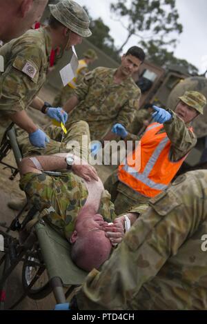 Warrant Officer Class 2 Bernadette Serong, Firma Sergeant Major 1. chirurgischen Gesellschaft, 2. Allgemeine Gesundheit Bataillon in Brisbane Australien gibt Anweisungen für Ihr Team beim Verschieben einer simulierten Unfall auf einer Bahre ProMIL 215 Warenkorb während einer Messe Unfallversicherung Übung an Williamson Airfield, Shoalwater Bay, Queensland Australien am 8. Juli 2017 während der Übung Talisman Sabre 2017. Übungen wie TS 2017 geben realistische, einschlägige Ausbildung notwendig, regionale Sicherheit, Frieden und Stabilität zu gewährleisten. Stockfoto