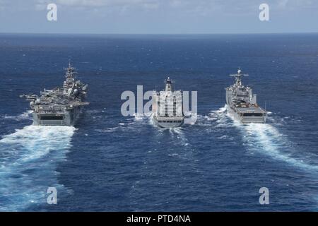 CORAL SEA (10 Juli 2017) Die Amphibious Assault ship USS BONHOMME RICHARD (LHD 6) parow Neben der Henry J. Kaiser-Klasse Flotte Auffüllung öler USNS John Ericsson (T-AO 194) und das Dock Landung Schiff USS Ashland (LSD 48) zur Auffüllung auf See während der Talisman Säbel. Bonhomme Richard, Teil einer kombinierten US-Australia-New Zealand Expeditionary strike Group, durchläuft eine Reihe von Szenarien, die Naval Fertigkeiten werden im Betrieb gegen den blauen erhöhen - Wasser kontradiktorischen Bedrohungen und in seiner primären Aufgabe der Einleitung Marine an Land in der littorals. Talisman Sabre ist ein Bien Stockfoto