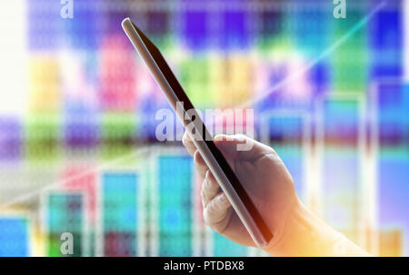 Mann mit Tablet-PC gegen verwackelte Finanzen charts Stockfoto