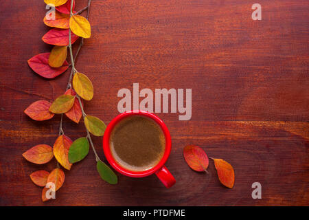 Rot Tasse Kaffee und bunten Herbst Blätter auf dem Holztisch. Ansicht von oben. Stockfoto