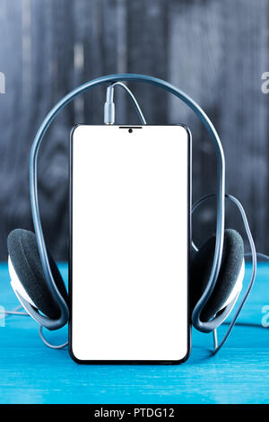 Moderne Blende weniger smart phone mit leerer Bildschirm und Kopfhörer. Musik Anwendung abstrakter Begriff. Stockfoto