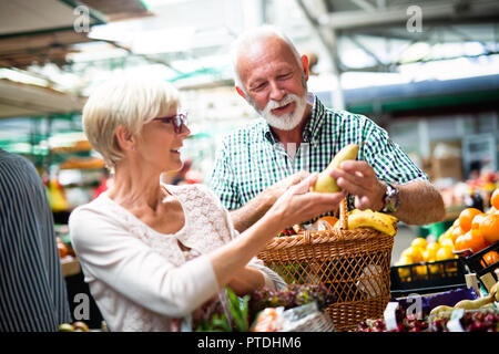 Senior Familie Paar Auswahl bio Lebensmittel Obst und Gemüse auf dem Markt beim wöchentlichen Einkauf Stockfoto