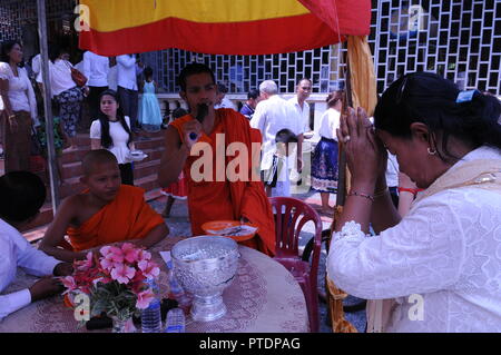 Provinz Kandal, Kambodscha. Oktober 29th, 2018. Einen kambodschanischen buddhistischen Mönch Gesänge über einen Lautsprecher, als Khmer Frau betet vor ihm, an einem Tempel während der Pchum Ben Festival, auch als 'Vorfahren' Day" bekannt. Credit: Kraig Lieb/Alamy leben Nachrichten Stockfoto