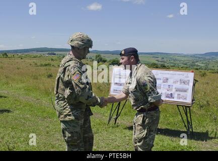 Generalleutnant Ben Hodges, kommandierender General der US Army Europe, präsentiert ein Vereinigtes Königreich Royal Monmouthshire Ingenieur Soldat mit seiner Münze als Zeichen der Anerkennung nach Erhalt einer gründlichen Kurze bei der Gemeinsamen National Training Center in Cincu, Rumänien vom 14. Juli 2017. Resolute Schloss 17 ist von April 14 - Sept. 30, 2017 in verschiedenen ‬Locations in Polen und Rumänien. Diese US-led, multinationale Übung, fördert die regionale Stabilität und Sicherheit, während des Trainings bau Ingenieure auf Ihre gemeinsame Mission Funktionen Stockfoto