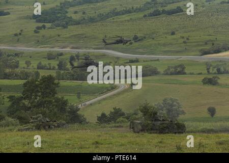 AH-64 Apaches vom 10 Combat Aviation Brigade und M2 Bradley Kampffahrzeugen vom 3. gepanzerte Brigade Combat Team, 4 Infanterie Division arbeiten im Tandem aus einer vorbereiteten Verteidigung während der kombinierten Waffen live fire Übung für Getica Sabre, 15. Juli 2017 in Cincu, Rumänien. Getica Sabre 17 ist eine von den USA geführte Fire Support Koordination und kombinierte Waffen live fire Übung umfasst sechs Verbündete und Partner Nationen mit mehr als 4.000 Soldaten. Getica Sabre 17 läuft gleichzeitig mit Säbel Guardian 17, ein US-European Command, U.S. Army Europe-led, multinationale Übung, die sich über Stockfoto