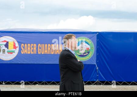 Der rumänische Präsident Klaus 26,13 macht Respekt für das Spielen des Rumänischen Nationalhymne während Verehrte Besucher Tag für Getica Sabre, 15. Juli 2017 in Cincu, Rumänien. Getica Sabre 17 ist eine von den USA geführte Fire Support Koordination und kombinierte Waffen live fire Übung umfasst sechs Verbündete und Partner Nationen mit mehr als 4.000 Soldaten. Getica Sabre 17 läuft gleichzeitig mit Säbel Guardian 17, ein US-European Command, U.S. Army Europe-geführten multinationalen Übung, erstreckt sich über Bulgarien, Rumänien und Ungarn, mit mehr als 25.000 service Mitglieder von 22 Alliierten und Partn Stockfoto