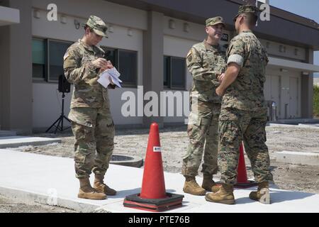 Us-Armee Oberstleutnant Dwayne Bechtol, öffentliche Gesundheit Aktivität Japan kommandierenden Offizier, Mitte, schüttelt Hände mit US Marine Corps Oberstleutnant Gary Thomason, der Marine Corps Air Station (WAB) Iwakuni Executive Officer, bei der Eröffnung der tierärztlichen Klinik bei WAB Iwakuni, 13. Juli 2017. Die neue Anlage wurde gebaut, um die wachsende Zahl von Patienten und Militär Hunde auf der Air Station unterzubringen. Die tierklinik ist verantwortlich für das Wohlergehen der Hunderte von militärischen Haustiere und militärische Arbeitshunde. Die neue Anlage ermöglicht Technikern das doppelte Menge der Patienten, die Sie sehen können Stockfoto