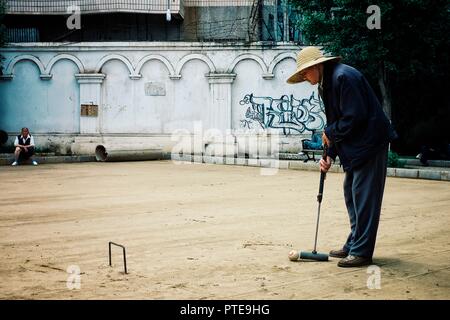 Xi'an/China - 24.Juni 2011: älterer Mann Krocket spielen in einem Park mit Freunden Stockfoto