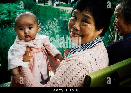 Xi'an/China - 24.Juni 2011: Oma mit Enkelin in einem Park mit Freunden Stockfoto