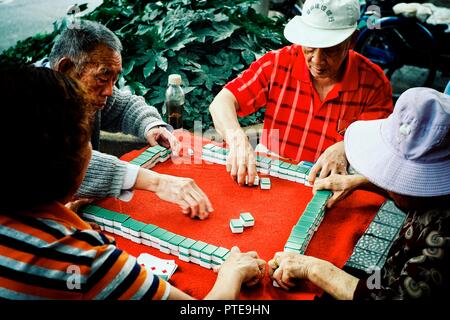 Peking/China - 24.Juni 2011: Ältere Menschen spielen Mahjong und Karten in einem Park im Freien Stockfoto