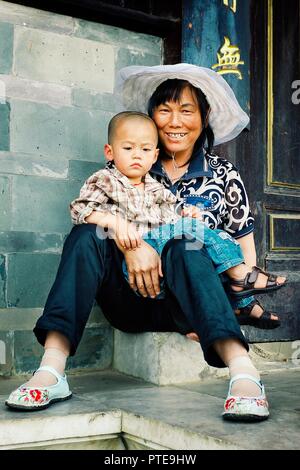 Peking/China - 24.Juni 2011: junge Mutter mit ihrem Kind vor den Toren des Tempels Stockfoto