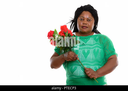 Studio Aufnahme von fetten schwarzen afrikanischen Frau mit roten Rosen bereit f Stockfoto