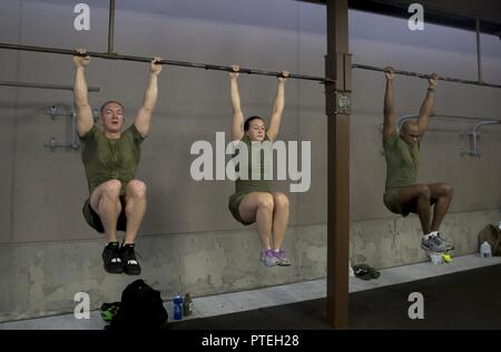 Us-Marines mit Marine Flugzeuge Gruppe 12 durchführen Knie verstaut während einer körperlichen Fitness Training von Kraft fitness Ausbilder an der Marine Corps Air Station Iwakuni, Japan, 18. Juli 2017 führte. Die Marines wurden von ihrem kommandierenden Offizier und Sergeant Major beigetreten sind, sowie US Marine Corps Brig. Gen. Thomas Weidley, Kommandierender General der 1. Marine Flugzeugflügel. Weidley war es die neue Marine Corps körperliche Fitness Programm, das hat sich seit seiner Einführung Anfang 2017 wächst zu unterstützen. Stockfoto