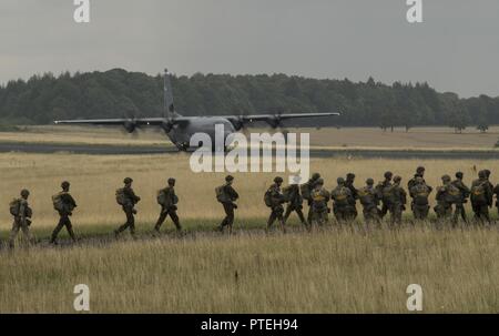 Fallschirmjäger aus mehreren NATO-Staaten gehen Sie in Richtung der US Air Force C-130J Super Hercules an Bord während der Internationalen springen Woche über Bitburg, Deutschland, 11. Juli 2017. Rund 500 Mitglieder aus mehr als 13 Partner Nationen in diesem Jahr an der Ausbildung teilgenommen haben. Stockfoto