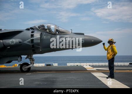 U.S. Navy Petty Officer 1st Class Juan F. Coello, eine Luftfahrt Bootsmann Mate zugeordnet zu den amphibischen Angriff Schiff USS Wasp (LHD-1), ein AV-8B Harrier Pilot, Marine Attack Squadron (VMA) 231 zugeordnet, auf dem Flugdeck des Wasp während des Fluges Zertifizierung Operationen, 16. Juli 2017. VMA-231 die Wespe in den Erwerb Flug Zertifizierungen in der Vorbereitung für die bevorstehende homeport Verschiebung nach Sasebo, Japan, wo Sie sind schiefergedeckt, die USS BONHOMME RICHARD (LHD 6) in der 7.Flotte Einsatzgebiet zu entlasten unterstützt. Stockfoto