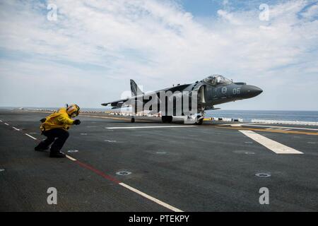 U.S. Navy Petty Officer 1st Class Juan F. Coello, einer Luftfahrt Bootsmann Mate's (Handling) zugeordnet die Amphibisches Schiff USS Wasp (LHD-1), ein AV-8B Harrier Pilot, Marine Attack Squadron (VMA) 231 zugeordnet, auf dem Flugdeck der Wasp, 16. Juli 2017. VMA-231 die Wespe in den Erwerb Flug Zertifizierungen in der Vorbereitung für die bevorstehende homeport Verschiebung nach Sasebo, Japan, wo Sie sind schiefergedeckt, die USS BONHOMME RICHARD (LHD 6) in der 7.Flotte Einsatzgebiet zu entlasten unterstützt. Stockfoto