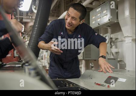 Pazifik (15. Juli 2017) Schäden Controlman 2. Klasse Tao Tian, ein Eingeborener von Tianjin, China, in die Engineering Abteilung zugewiesen an Bord der Amphibisches Schiff USS America (LHA 6), prüft ein wassernebel Pumpe in einer der Hauptstraßen der schiffsdieselmotors Zimmer. Amerika ist derzeit auf seinem Jungfernflug Bereitstellung begonnen und ist Teil der Amerika Amphibious Ready Gruppe besteht aus mehr als 1.800 Segler und 2.600 Marines zu den Amphibischen dock Landung Schiff USS Pearl Harbor (LSD 52), die amphibious Transport dock Schiff USS San Diego LPD (22) und Nordamerika zugeordnet. Stockfoto