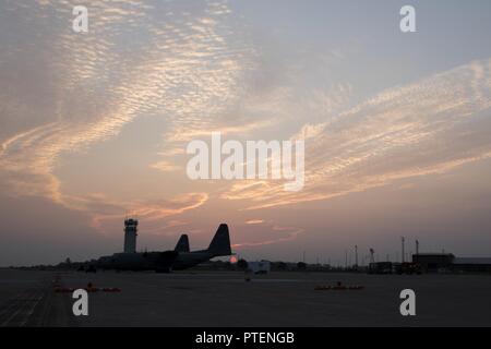 Die Sonne über dem C-130H Hercules auf der flightline an der 179th Airlift Wing, Mansfield, Ohio, am Morgen des 19. Juli, 2017. Die 179Th Airlift Wing ist immer auf einer Mission, die erste Wahl zu sein, Gemeinschaft, Bund und Missionen mit einem zuverlässigen Team von hoch qualifizierten Piloten zu reagieren. Stockfoto