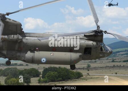 Eine griechische CH-47 Chinook Rotary-Flugzeugen und eine AH-64 Apache bieten eine Unterstützung bei der kombinierten Waffen live Fire Training Juli 20, 2017 bei Novo Selo, Bulgarien während der Übung Sabre Guardian 17. Sabre Guardian ist ein US-Army Europe-led, multinationale Übung, erstreckt sich über Bulgarien, Rumänien und Ungarn, mit mehr als 25.000 service Mitglieder aus 22 NATO-Mitglieder und der Partnerstaaten. Stockfoto