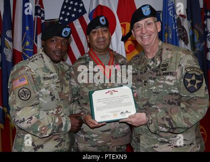 Generalmajor Theodore D. Martin, die 2 Infantry Division/ROK-US kombinierte Division Commander und Command Sgt. Maj. Edward W. Mitchell, der 2 Infanterie Division/ROK-US kombinierte Abteilung command Sergeant Major, präsentiert die Vereinigten Staaten der amerikanischen Legion of Merit Award an ausgehende 210th Field Artillery Brigade command Sergeant Major, Command Sgt. Maj. Carlos G. Gonzalez-Pabon, am Carey Fitnessraum, Camp Casey, Südkorea, 12. Juli 2017. Gonzalez-Pabon verdient die Auszeichnung für seine Beiträge zur 210Th FA BDE. und 2 ID, während die Brigade command Sergeant Major von Juli 2015 bis Juli 2017 dienen. Stockfoto