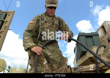 ​Indiana National Guard Pfc. Ronald Adams, von Warschau und eine Multichannel Übertragungssysteme Fahrer und Betreuer mit der Firma C, Feuerwehr 776th Engineer Battalion, verbindet die Alternative aktuelle Netzkabel von einem Humvee mit einem Generator in Fort Polk, Louisiana, Mittwoch, 19. Juli 2017. Adams ist eine von rund 6.100 Service Mitglieder die Teilnahme an oder die Unterstützung bei der 76th Infantry Brigade Combat Team das 12-tägige Schulung Schlacht an der Louisiana post. Stockfoto