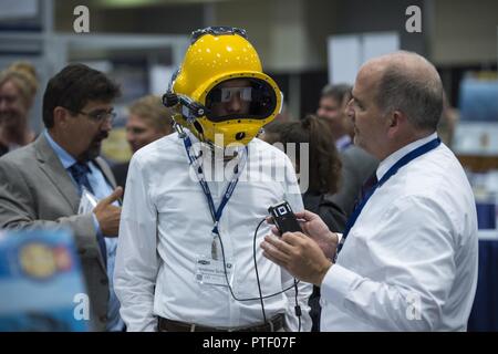 WASHINGTON (Jan. 20, 2017) Dennis Gallagher, ein Ingenieur von der Naval Surface Warfare Center, Panama City, erklärt die Taucher Augmented Vision Display (DVAD) um einen Teilnehmer während der Amtszeit des Naval Research Naval Zukunft Kraft von Wissenschaft und Technologie (W&T) Expo am Walter E. Washington Convention Center. Die DAVD ist ein hochauflösendes, sehen - durch Heads-up-Display (HUD) direkt im Inneren eines tauchen Helm, mit der Taucher eine visuelle Anzeige der alles von Sektor Sonar, Text, Grafiken, Fotos und sogar augmented reality Videos eingebettet. Stockfoto