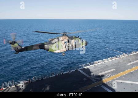 CORAL SEA (Juli 19, 2017) ein Royal Australian Navy MRH-90 Taipan Hubschrauber hebt ab Amphibisches Schiff USS BONHOMME RICHARD (LHD6) während der Talisman Sabre 17. Talisman Säbel ist eine Biennale USA - Australien bilaterale Übung gehalten weg von der Küste von Australien gedacht, um die Interoperabilität zu erreichen und den USA - Australien Bündnis stärken. Stockfoto