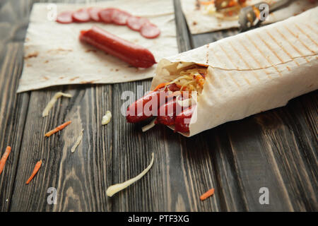 Geräucherte Wurst in pita Brot auf hölzernen Hintergrund Stockfoto