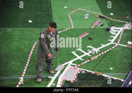 Us Air Force Reserve Oberstleutnant Brett Schumer, 302Nd Airlift Wing Bereitstellung mission Commander, Spaziergänge der C-130 Herkules Flugzeug Modell durch einen simulierten Flug Muster als Teil einer gemeinsamen Probe während der Übung die schnelle Reaktion 17 am Papa Air Base, Ungarn, 17. Juli 2017. Das Modell der Stadt wird sorgfältig gebaut von U.S. Army Personal zu skalieren, um eine genaue Darstellung der Umgebung zu haben. Schnelle Antwort links Sabre Guardian 17, ein US-Armee Europa auszuüben - led, multinationale Übung, erstreckt sich über Bulgarien, Rumänien und Ungarn, mit mehr als 25.000 Mitgliedern aus 22 alle Service Stockfoto