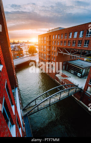 Die HafenCity. Brücke über den Kanal und die roten Backsteinbauten in der Speicherstadt Die Speicherstadt in Hamburg in der Goldenen Stunde Sonnenuntergang Licht, Deutschland. Ansicht von oben Stockfoto