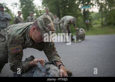 Staff Sgt. Dustin Rottero, ein Personalvermittler mit Tennessee Army National Guard Recruiting und Retention Bataillon, Tennessee National Guard, strafft die Gurte auf seinem Ruck sack vor dem 13.1-Meile ruck März durch Itasca State Park, Minn. für die Army National Guard 2017 besten Krieger Wettbewerb am 20. Juli 2017. Die Soldaten abgeschlossen, eine anstrengende Drei - Tage der militärischen Fähigkeit, Kraft und Ausdauer Ereignisse vor der Ruck März. (Minnesota National Guard Stockfoto