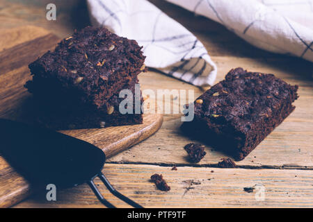 Vegan Zucchini und Kürbis flourless Paleo brownies brownies (Keto, low Carb und Glutenfreie) auf einem hölzernen Hintergrund. Nahaufnahme Stockfoto