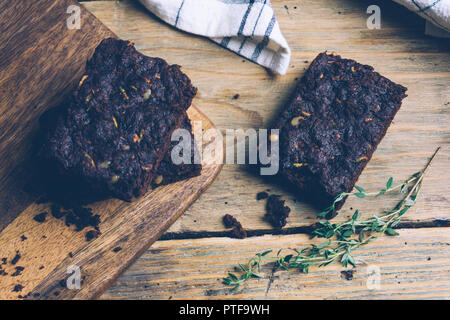 Vegan Zucchini und Kürbis flourless Paleo brownies brownies (Keto, low Carb und Glutenfreie) auf einem hölzernen Hintergrund. Nahaufnahme Stockfoto