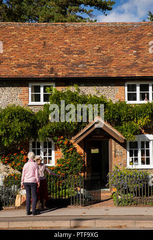 England, Berkshire, Goring an der Themse, High Street, Frauen chatten außerhalb Idyllisch, traditionell erbaute Brücke Haus mit kleinen Garten Stockfoto