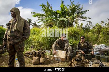 Us Marine Corps Sgt. Ian Pass, Mitte, eine Maschine Schütze mit 3 Battalion 4th Marines, öffnet sich eine Kiste Munition während der Übung TAFAKULA, auf der Insel Tongatapu, Tonga, 21. Juli 2017. Übung TAFAKULA ist entworfen, um die militärische zu stärken, und die Beziehungen zwischen der Tonga His Majesty's Armed Forces, Französischen Armee von Neukaledonien, Neuseeland Defence Force, und die Streitkräfte der Vereinigten Staaten. Stockfoto