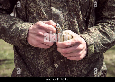 Granate, Hände auf Pin. der Soldat zieht einen Scheck von einer splittergranate RGD-5. Self-Explosion. Stockfoto