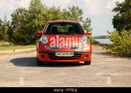 DNIPRO, UKRAINE - August 10, 2016: NISSAN MICRA FARBE ORANGE IN DER NÄHE DES FLUSSES IN DER STADT Stockfoto