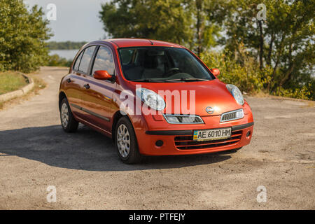 DNIPRO, UKRAINE - August 10, 2016: NISSAN MICRA FARBE ORANGE IN DER NÄHE DES FLUSSES IN DER STADT Stockfoto