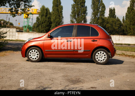 DNIPRO, UKRAINE - August 10, 2016: NISSAN MICRA FARBE ORANGE IN DER NÄHE DES FLUSSES IN DER STADT Stockfoto