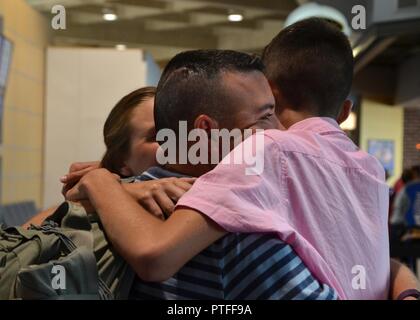 Senior Master Sgt. Nathan Hooton, der 442 d Bauingenieur Squadron Operationen Flug Betriebsleiter, umarmt schließt seine Familie am internationalen Flughafen Kansas City in Kansas City, Mo, 19. Juli 2017. Die Mitglieder des 442 d Mission Support Group an mehrere Standorte in Asien Soutwest zur Unterstützung der Operation der entschlossenen Unterstützung bereitgestellt werden. Stockfoto