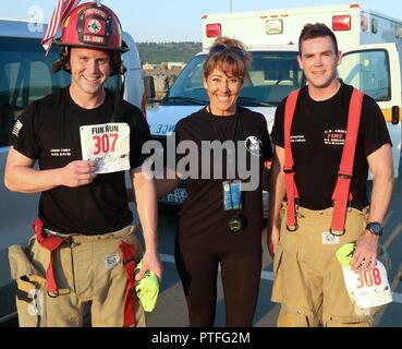 Sgt. Alek Davis (links) und Sgt. Curtis Carlin (rechts) Der 487Th Engineering Ablösung (Feuerwehr), US Army Reserve, Fort Des Moines, Iowa, eine Pause für ein Foto mit Veranstalter Maria Diaz (Mitte), Fitness Koordinator, US Army Moral Wohlbefinden und Erholung (MWR) bei Novo Selo Training Area (Nsta), Bulgarien, am 21. Juli 2017. Die Soldaten abgeschlossen ein Rennen 5K auf NSTA in voller "Turn-out"-Gang in Teil gefallene Feuerwehrmänner zu ehren. Stockfoto