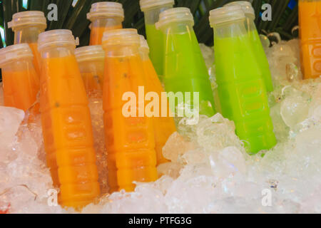 Flaschen von Passionsfrucht und Mango, Guave, Säfte auf Ice Box Waren zum Verkauf wie frisches Obst Saft bei Street Food angezeigt mit Preisschild abgewürgt. Stockfoto
