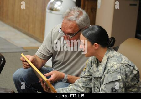 Sgt. Angela Myers, 311 ESC Munition Sergeant, schaut über Fotos, den sie nie mit ihrem Onkel Corey Rose gesehen. Dies ist Myers zum ersten Mal treffen ihr Onkel oder die biologische Familie. Sie war in Pflege angehoben. Stockfoto