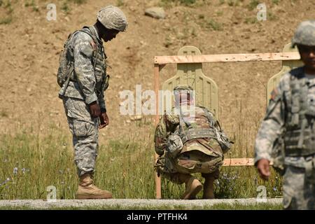 New York Army National Guard Soldat, Staff Sgt. Mykel Christoffersen (rechts), um die 107 Militärpolizei Unternehmen zugewiesen sind, untersucht ein Schüler nullstellen Ziel auf dem Camp Smith Training Website, Cortlandt Manor, N.Y., 18. Juli 2017. Christoffersen ist ein Kader Mitglied mit der zukünftige Führer Kurs, und war den Studenten Tipps, wie genauer zu schießen, weil Treffsicherheit eine wichtige Fähigkeit ist für Führungskräfte im Militär. Die Ausbildung war ein Teil der New York Army National Guard zukünftige Führungskräfte Kurs, ein Pilotprogramm zur Vorbereitung Soldaten, Unteroffiziere geworden. Stockfoto