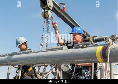 Pazifik (21. Juli 2017) Feuer Controlman 3. Klasse Brenda Sanchez, ein Eingeborener von Kalispelin, Montana, und Feuer Controlman 1. Klasse Ronald Dupra, ein Eingeborener von Riverside, Kalifornien, zum Combat Systems Abteilung zugewiesen an Bord der Amphibisches Schiff USS America (LHA 6), laden Sie eine Boden-Luft-Rakete abzufangen, 162 D in einem Rolling airframe Missile Launcher auf dem Schiff Rakete deck. Amerika ist derzeit auf seinem Jungfernflug Bereitstellung begonnen und ist Teil der Amerika Amphibious Ready Gruppe besteht aus mehr als 1.800 Segler und 2.600 Marines zu den Amphibischen dock Landung Schiff zugewiesen Stockfoto