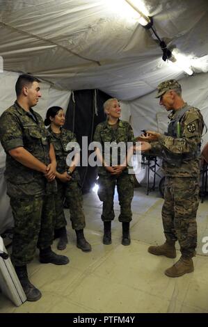 Oberstleutnant David Douglas, ein Beobachter Trainer Trainer mit medizinischen Bereitschaft und Weiterbildung Befehl, spricht mit kanadischen Kräfte finden Personal (nach rechts: Cpl. Nick Kennedy, medizinischer Techniker; Kapitän Jenny Vuong, eingetragene Krankenschwester, und Leutnant Kat Rees, Registered Nurse), die mit der 345 Combat Support Hospital während der globalen Medic 2017 am Fort Hunter Liggett, Kalifornien integriert. Die fast 250 Soldaten in die CSH zugewiesen haben die ersten paar Tage einrichten das Krankenhaus und das Erhalten sie bereit zu beginnen, die Patienten. Die Übung läuft 8-28 Juli 2017. Global Medic einzigartige Training op Stockfoto